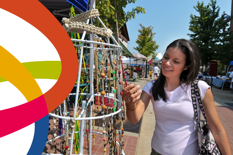 Woman viewing handmade jewelry at an outdoor market