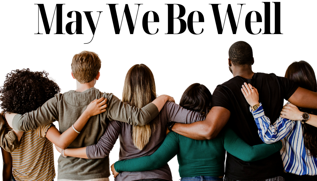 People standing with hands on each others' shoulders pictured from behind