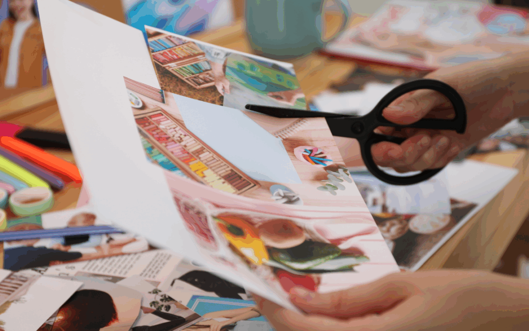 Someone cutting out images from a sheet of paper with scissors
