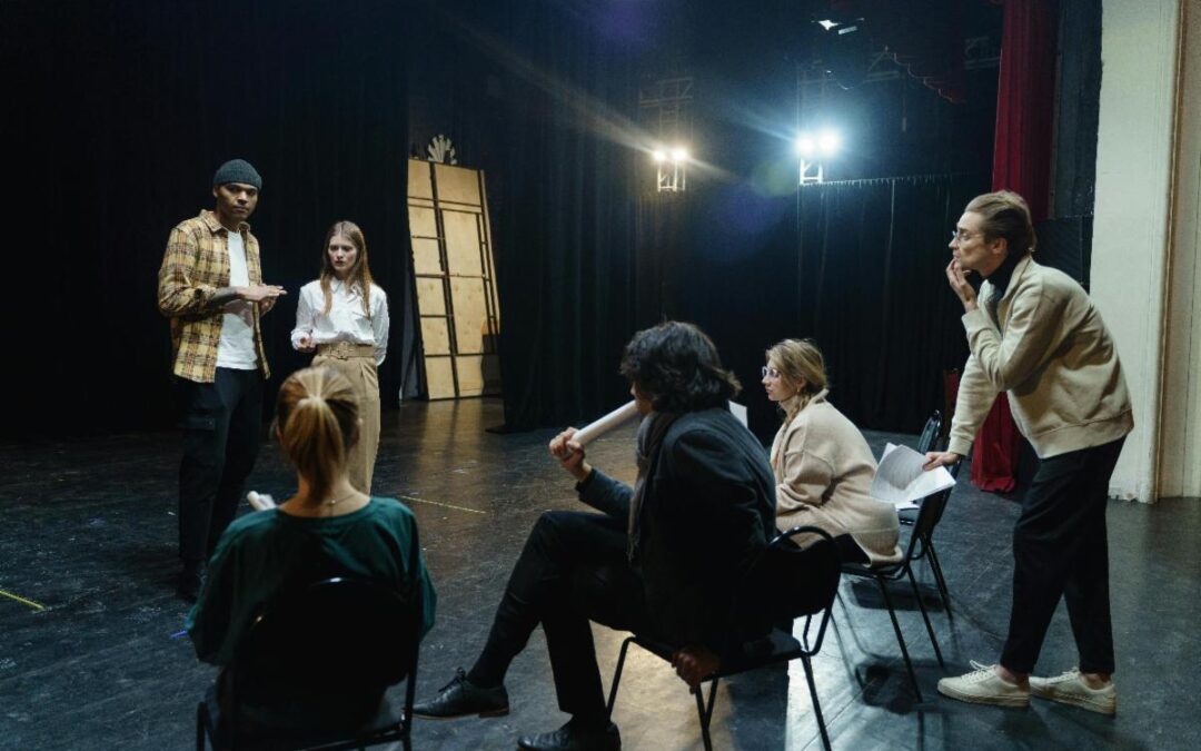 A group of adults discussing something on stage