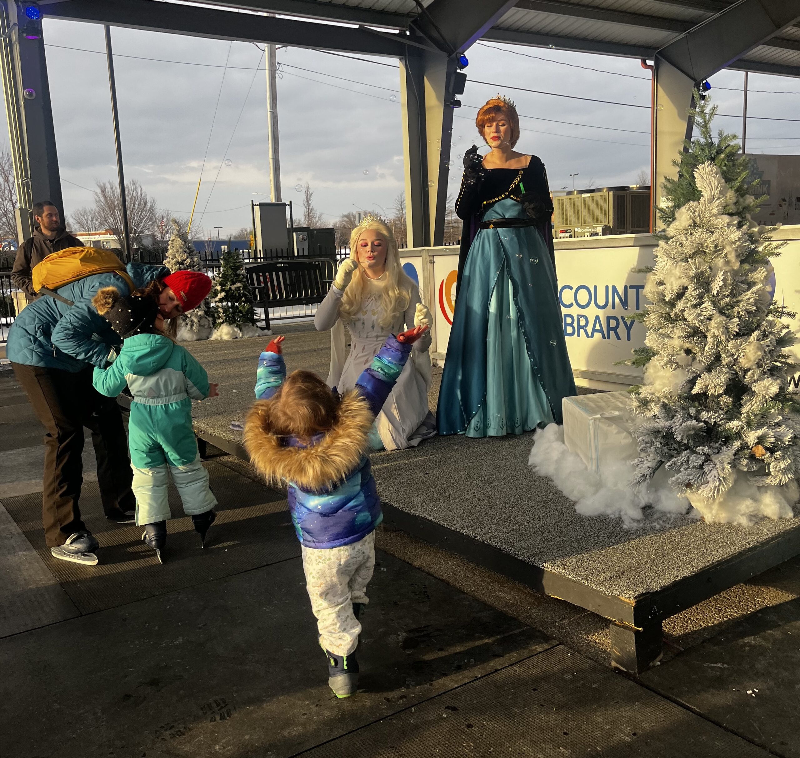 Frozen's Elsa and Anna blow bubbles at the ice rink with children